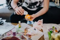 Kaboompics - Young Girl Applying White Decoration to an Orange Easter Egg