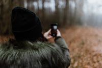 Kaboompics - A woman takes a picture with her iPhone X in the autumn forest