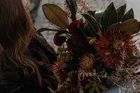 Kaboompics - Woman Holding a Large Autumn Flower Bouquet on a Park Bench