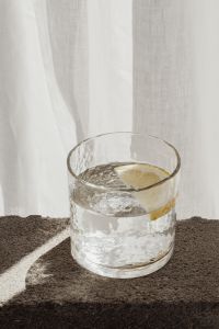 Kaboompics - Lemon Water Glass Styled Against Sheer Curtains