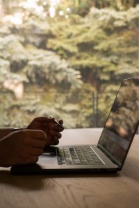 Kaboompics - Man Working on a Laptop in Front of a Garden View