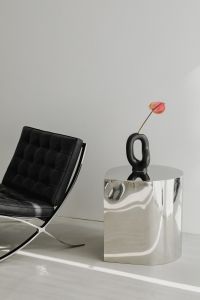 Kaboompics - Black Leather Chair with Black Sculptural Vase and Anthurium