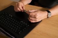 Kaboompics - Man Holding a Stylus Above a Laptop Keyboard