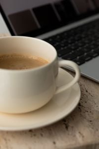Kaboompics - Close Up of Coffee Cup With Laptop in Background