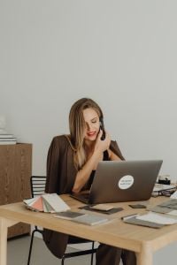 Kaboompics - Woman Talking on Phone Beside Open Laptop