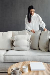 Kaboompics - Woman Tidying Pillows in a Calm Living Room