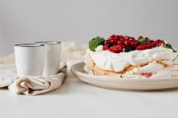 Kaboompics - Whole Berry Pavlova and Two Empty White Coffee Cups on a Pale Table