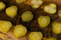 Kaboompics - Round Pickle Slices on Rustic Wooden Board, Macro Food Background