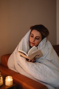 Kaboompics - Woman Reading a Book Wrapped in a Cozy Blanket