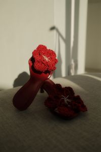 Kaboompics - Red Crochet Sandals Styled on a Neutral Upholstered Chair with Playful Overlap