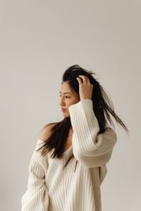 Neutral At-Home Lifestyle Portraits of a Woman in Loungewear, Using a Smartphone and Styling Her Hair