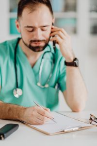 Kaboompics - Doctor Listening on Phone at Desk