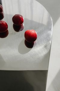 Kaboompics - Red Plums on Rounded Chrome Tabletop