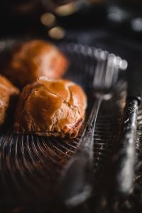 Kaboompics - Single Golden Sweet Bun in Focus with Blurred Pastries