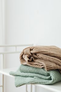 Kaboompics - Folded Sage and Beige Sweaters
