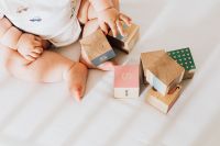 Kaboompics - Newborn Baby with Wooden Toy Blocks on White Blanket, Overhead