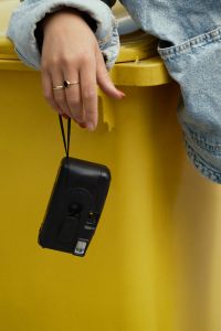 Kaboompics - Hand Holding A Disposable Camera Over A Recycling Bin