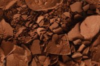 Kaboompics - Terracotta Clay Surface with Scattered Fragments and Irregular Cracks