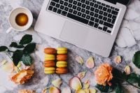 Kaboompics - Overhead Home Office Flat Lay with Macarons, Espresso and Laptop among Peach Roses