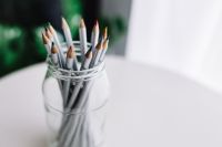 Kaboompics - Colored Pencils in a Glass Jar on White Desk, Minimal Creative Workspace with Soft-Focus Background