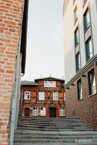 Kaboompics - Vertical Gdańsk Courtyard View Framed by Brick Walls, Stone Steps and Historic Timber Facade