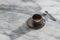 Kaboompics - Chrome Espresso Cup and Spoon on Veined Arabescato Marble, Minimal Coffee Background with Copy Space