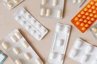 Kaboompics - White and Orange Pill Blister Packs on Beige, Overhead Pharmacy Still Life for Healthcare Design