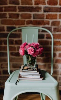 Kaboompics - Industrial pale green metal chair with a bouquet of pink flowers and books on it