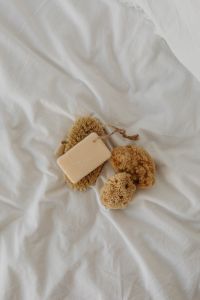 Kaboompics - Natural Soap Bar and Sea Sponges with Body Brush on White Linen