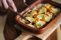 Kaboompics - Serving Fish Casserole from a Rustic Ceramic Baking Dish