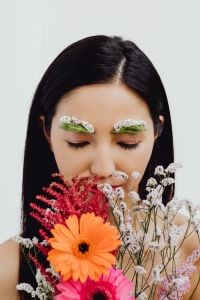 Kaboompics - Vertical Beauty Portrait with Orange Gerbera and Pink Bouquet Covering the Lower Face