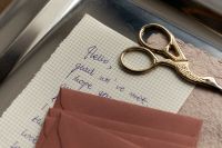 Kaboompics - Handwritten Letter with Gold Scissors and Pink Envelopes on Tray
