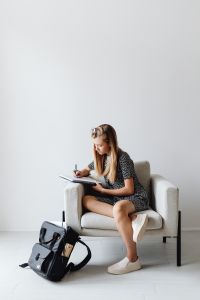 Kaboompics - Student Writing Homework with Backpack