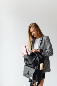 Kaboompics - Teen Student Packing a Black School Backpack with Notebook and Folder