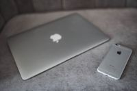 Kaboompics - Silver laptop and an iPhone on a grey sofa
