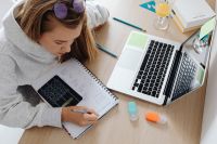 Kaboompics - Teenager Solving Math Homework with Calculator and Laptop