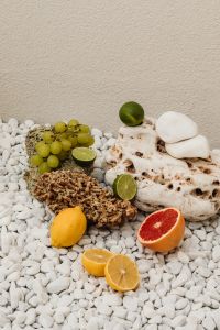 Kaboompics - Wide Fruit Still Life with Citrus and Grapes on White Pebbles
