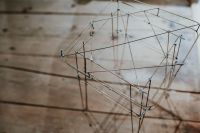 Kaboompics - Sculptural Metal Wire Chair on Wooden Exhibition Floor, Angled View