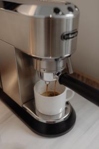 Kaboompics - DeLonghi Espresso Machine Pouring into a White Mug