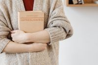Kaboompics - Books Held Close to a Wool Sweater for Cozy Bookstore and Reading Promotion