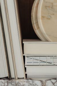Kaboompics - Close-Up of White Book Spines and a Round Marble Tray