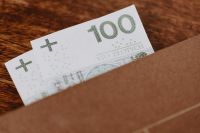 Kaboompics - 100 Polish Zloty Banknote Peeking from Brown Envelope on Wood