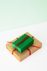 Kaboompics - Close-Up of Green and Gold Gift Boxes with Red Ribbon