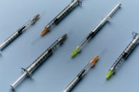 Kaboompics - Scattered Medical Syringes on Blue Background