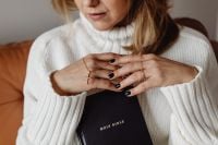 Kaboompics - Hands Crossed Over a Holy Bible in Soft Knitwear