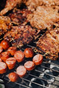Kaboompics - Vertical Macro of Glazed Pork Neck and Sausage on Black Grill Bars