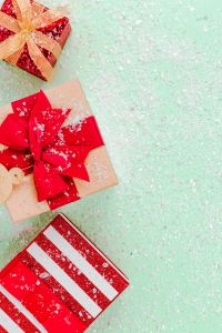 Pastel Green Christmas Gift Flat Lay with Red Bows and Snowy Details