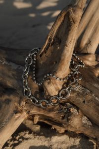Kaboompics - Layered Silver Chain Necklaces Draped over Driftwood