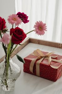 Kaboompics - Pink Daisies and Red Roses with Wrapped Gifts Beside a Bright Window