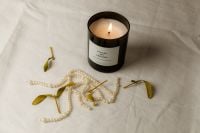 Kaboompics - Lit Black Glass Candle with Pearls and Dried Leaves